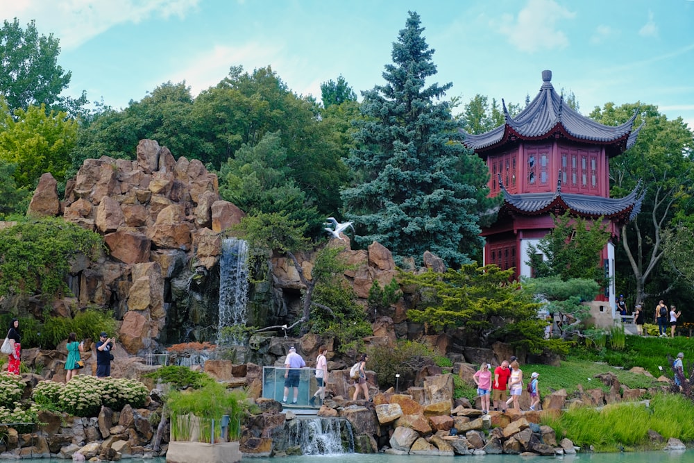 a group of people standing around a pond