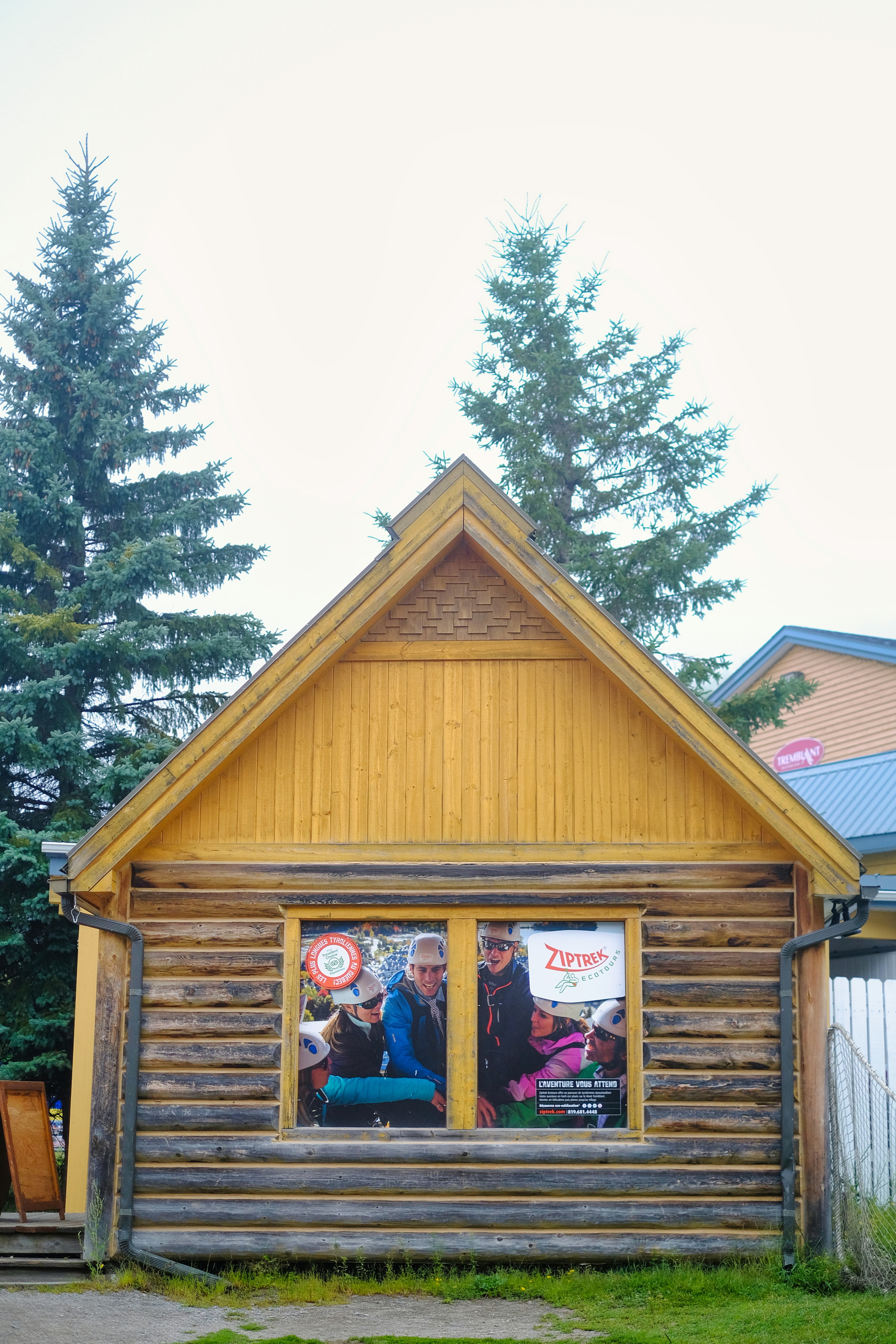 a log cabin with two windows and a poster on the front