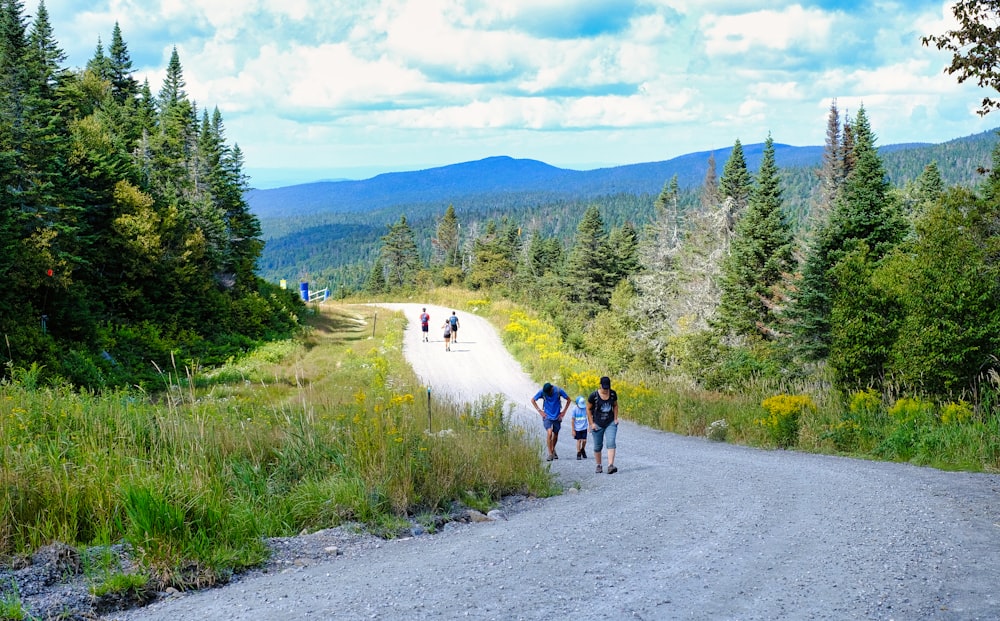 a couple of people walking down a dirt road