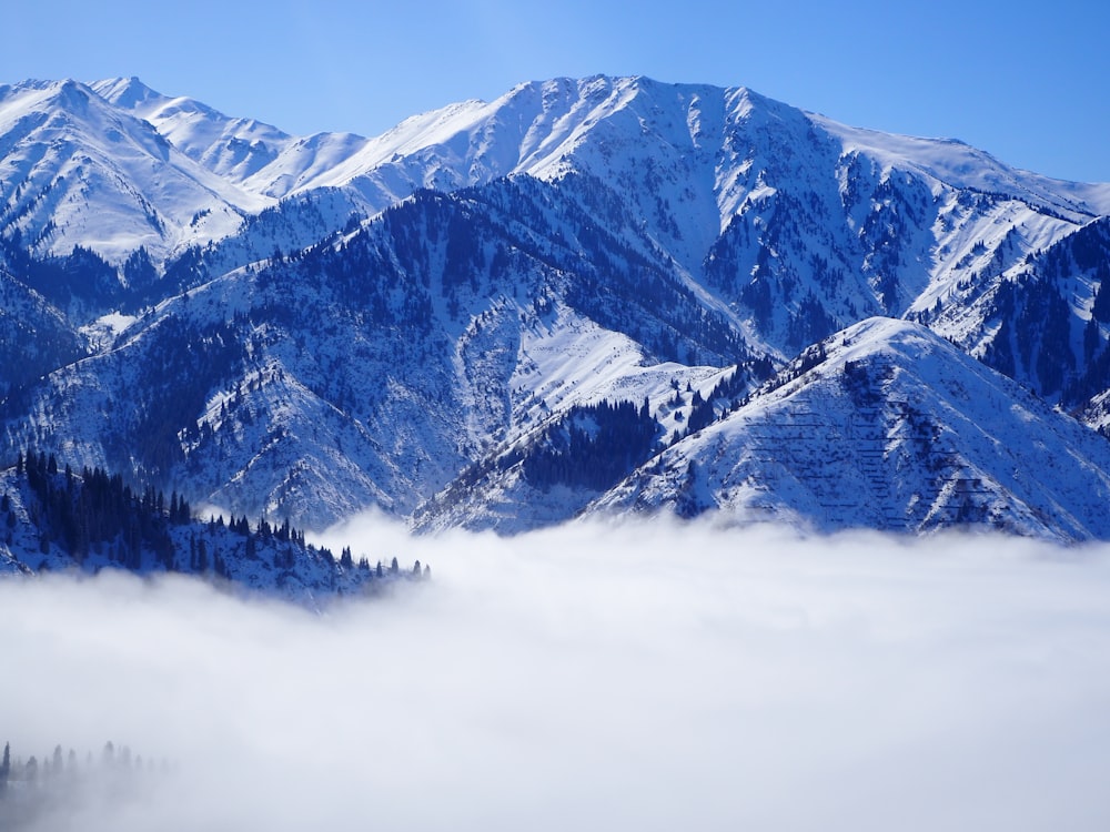 a mountain range covered in snow and clouds