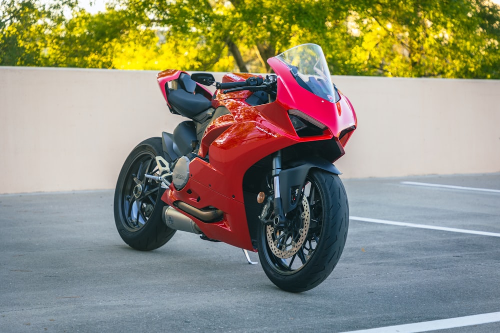 a red motorcycle parked in a parking lot