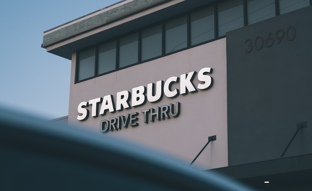 a sign on the side of a building that says starbucks's drive thru