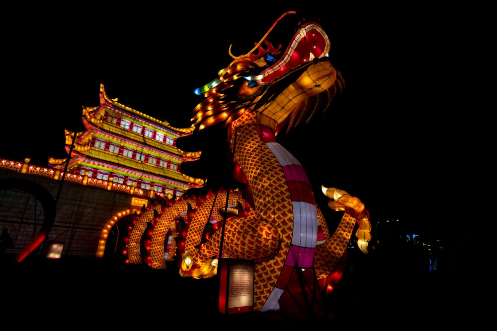 a dragon statue is lit up at night