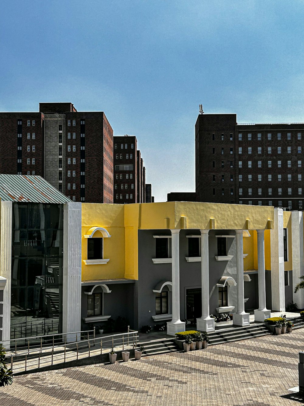 a yellow and grey building with white pillars