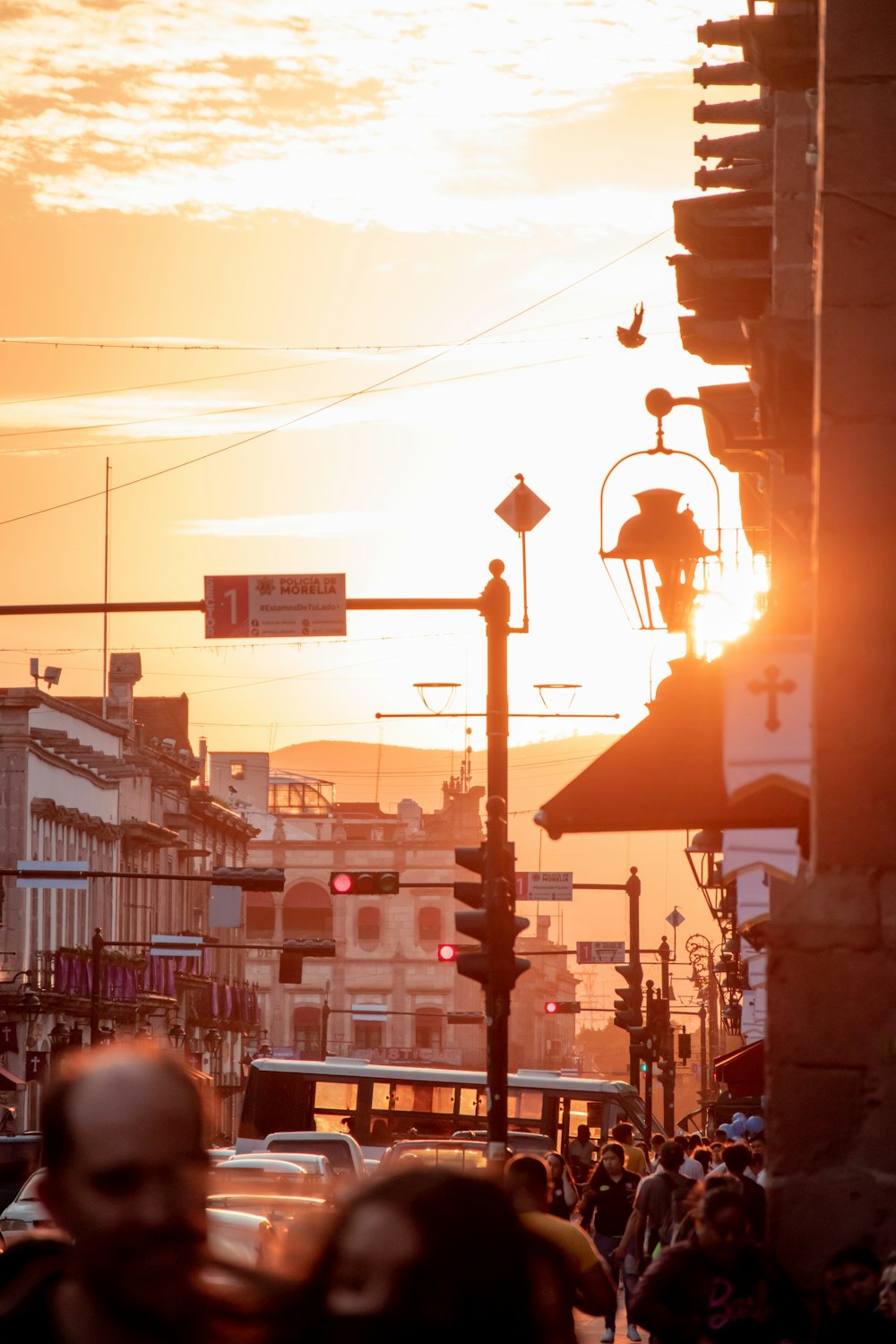 the sun is setting over a busy city street