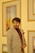 a man in a suit and tie standing in front of paintings