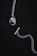 A silver chain with a prominent pendant at one end shaped like a detailed dog head and a small gold bone-shaped toggle clasp on a dark background. The overall composition is minimalistic and artistic, highlighting the metallic textures and intricate designs of the jewelry piece.