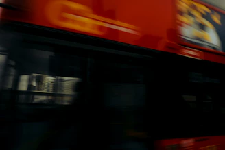 A busy city bus wrapped in eye-catching advertising graphics driving through a crowded urban area.