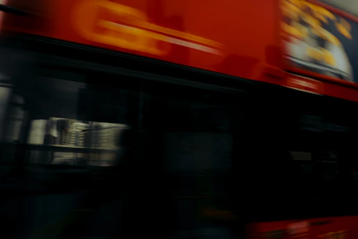 A busy city bus wrapped in eye-catching advertising graphics driving through a crowded urban area.