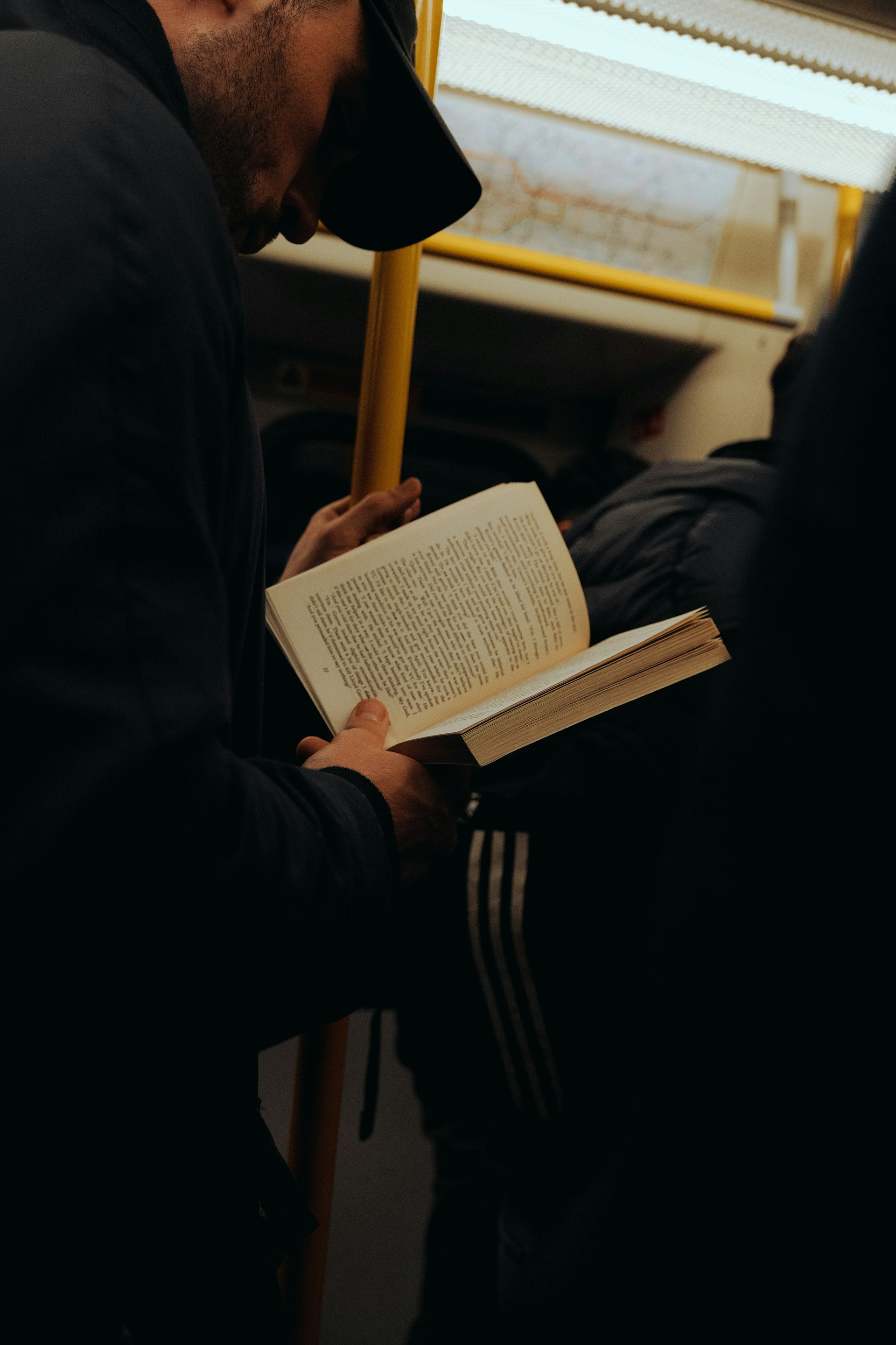 a man reading a book on a train
