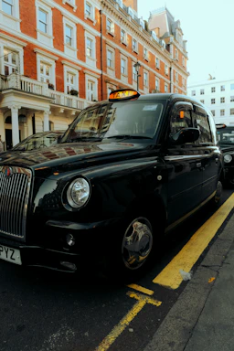 A sleek black taxi parked outside a charming Paddington street, ready for a trip.