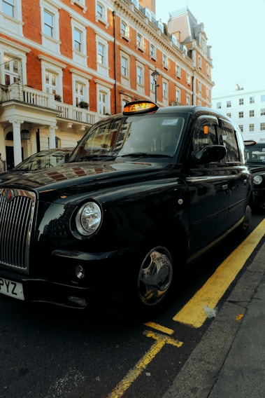 A sleek black mini cab parked outside Heathrow Airport, ready for passengers.