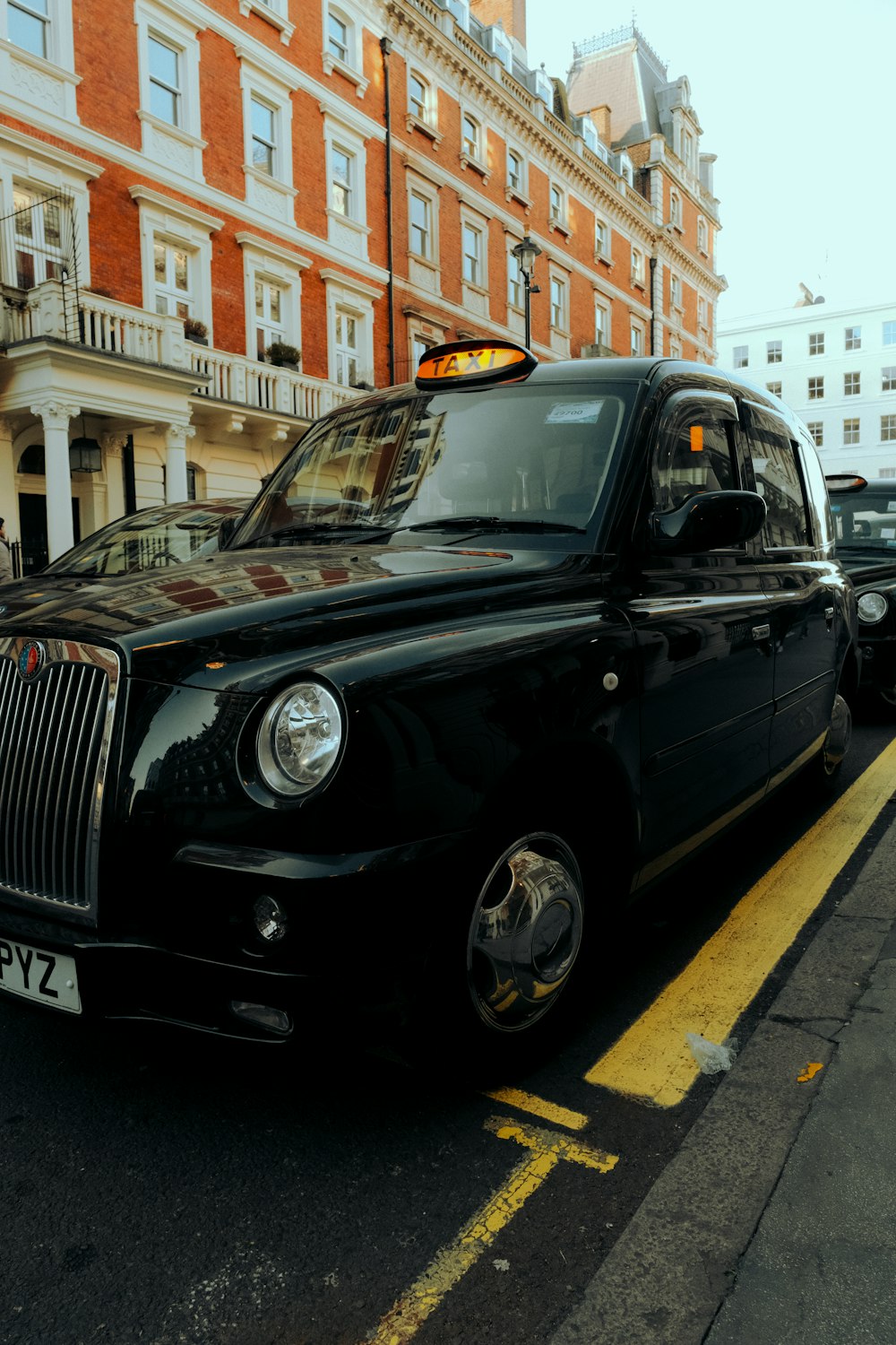 a black taxi cab parked on the side of the road