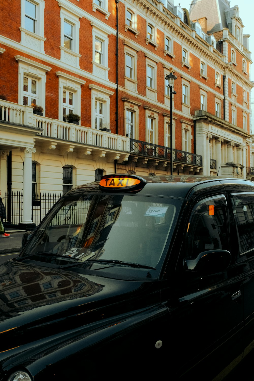 a black taxi cab parked in front of a tall building