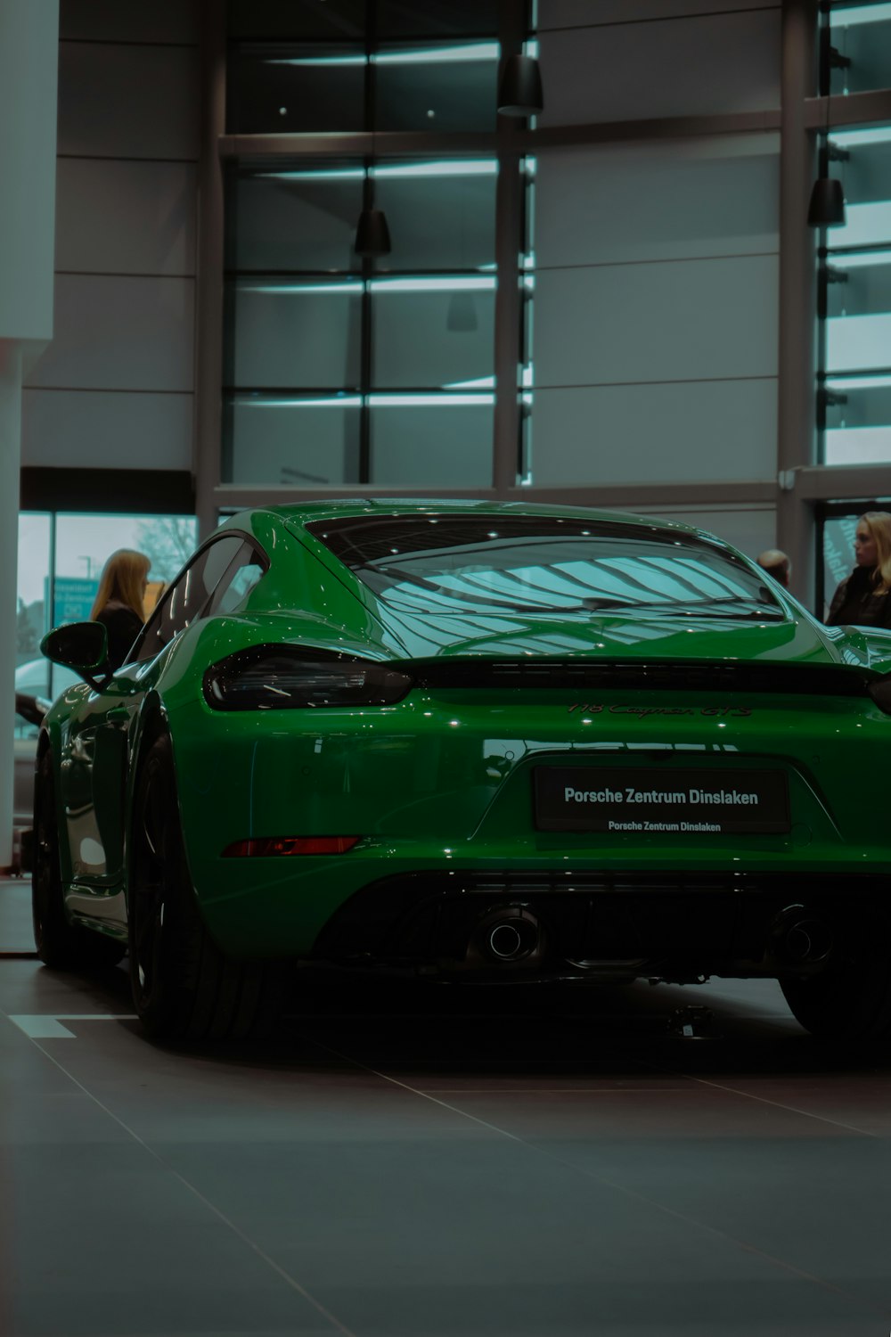 a green sports car parked in front of a building