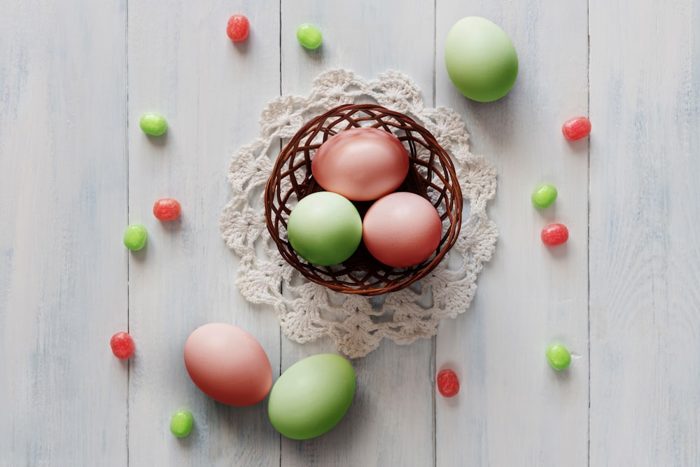 a basket filled with green and pink eggs