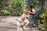 A happy woman sitting on a park bench with her golden retriever, both looking healthy and content.