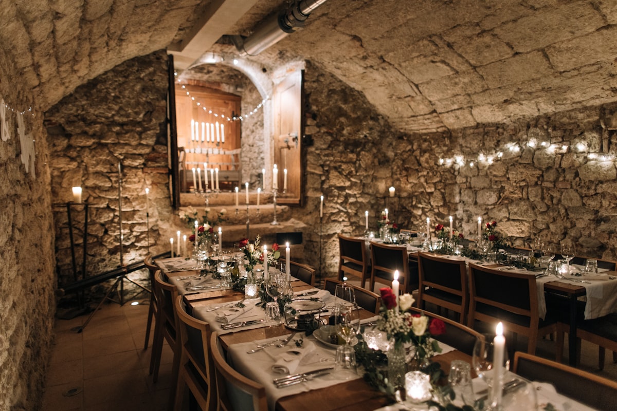 Candlelit dinner table in a historic stone-walled venue