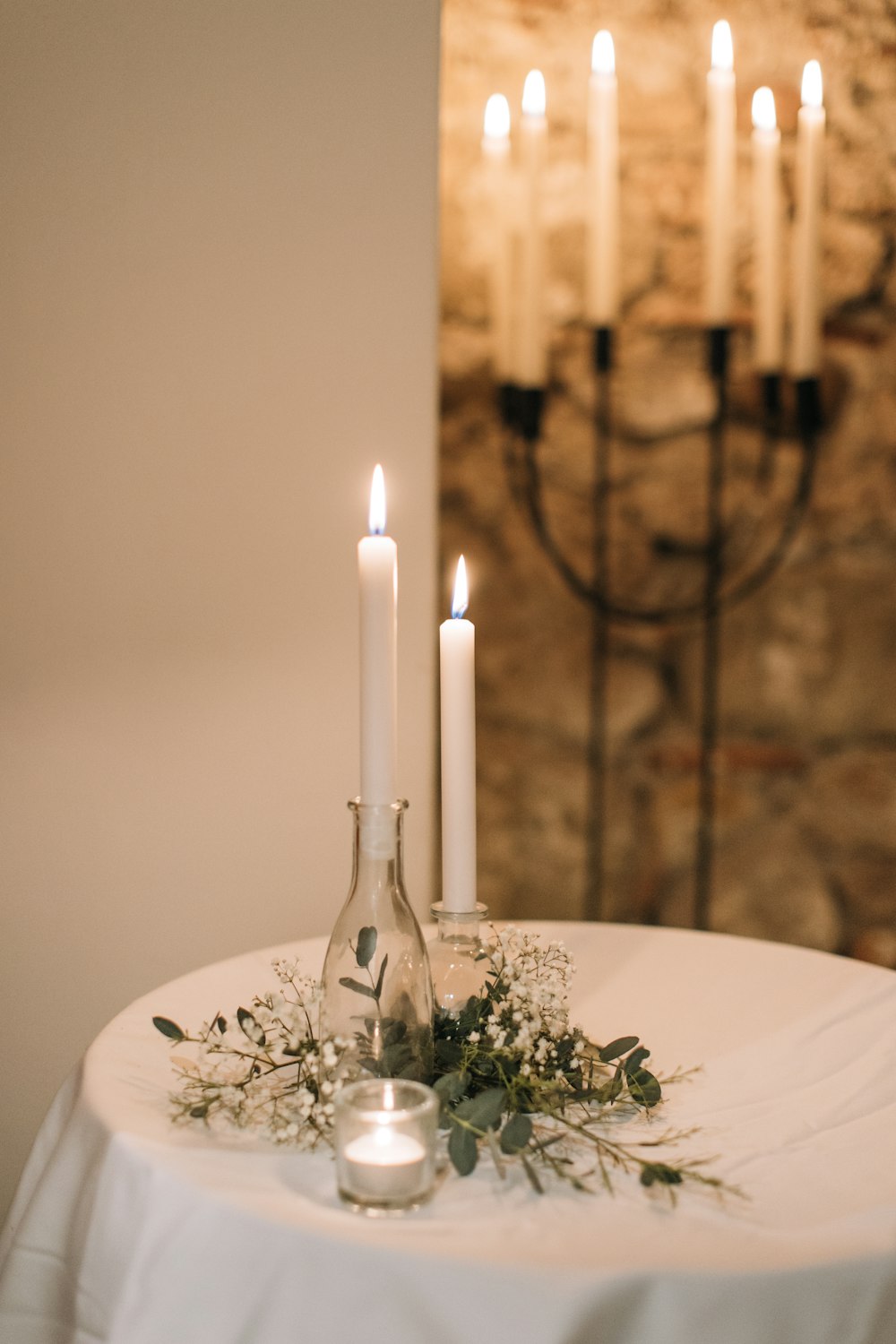 a table topped with a bottle filled with candles