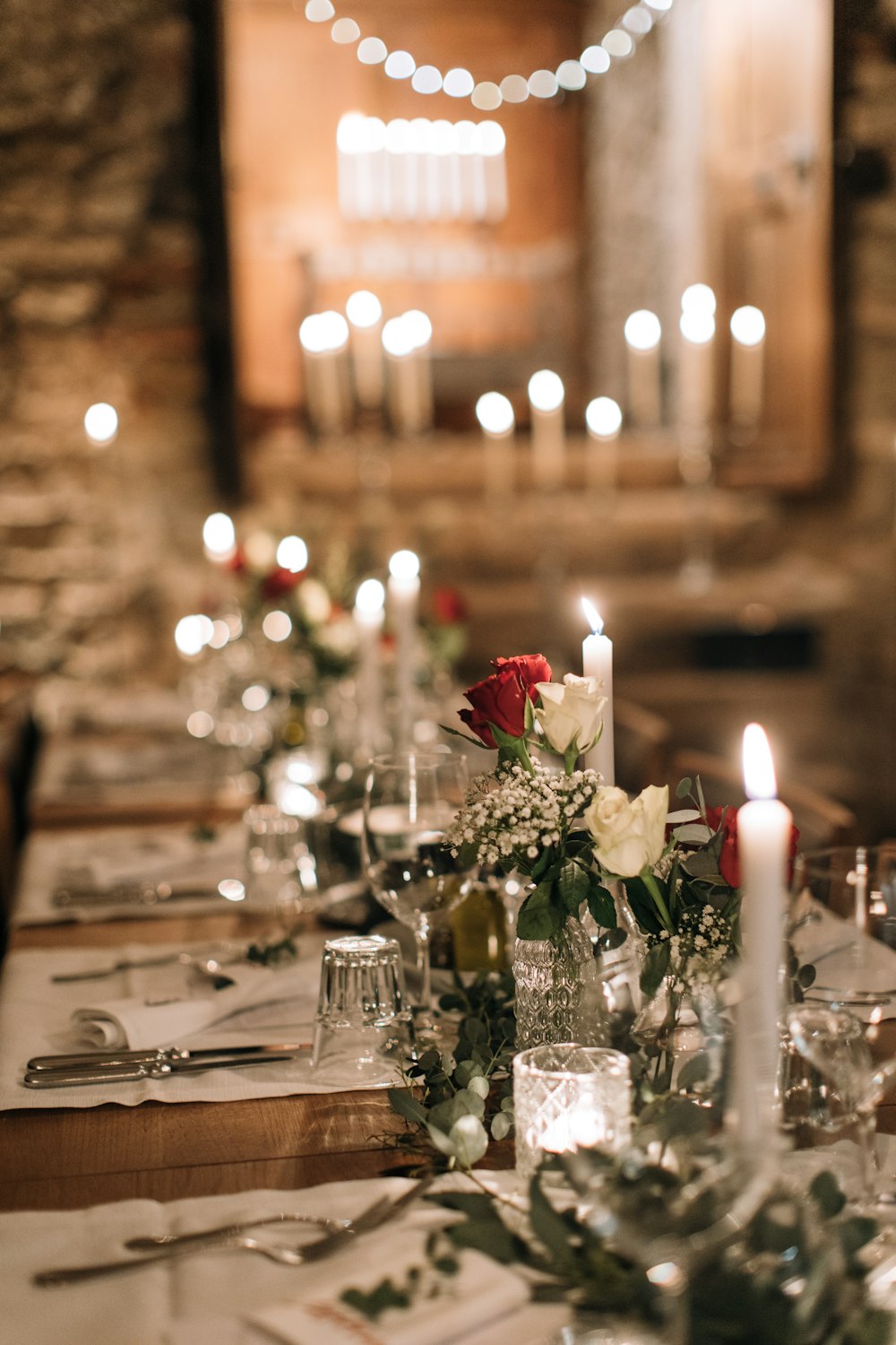 a long table with candles and flowers on it