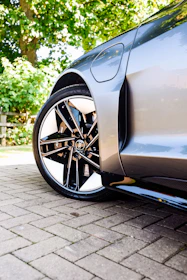 Wheels gleaming with fresh tire shine, parked on a dark asphalt driveway at dusk.