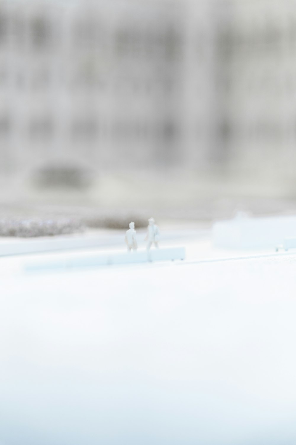 a couple of tiny figurines sitting on top of a window sill