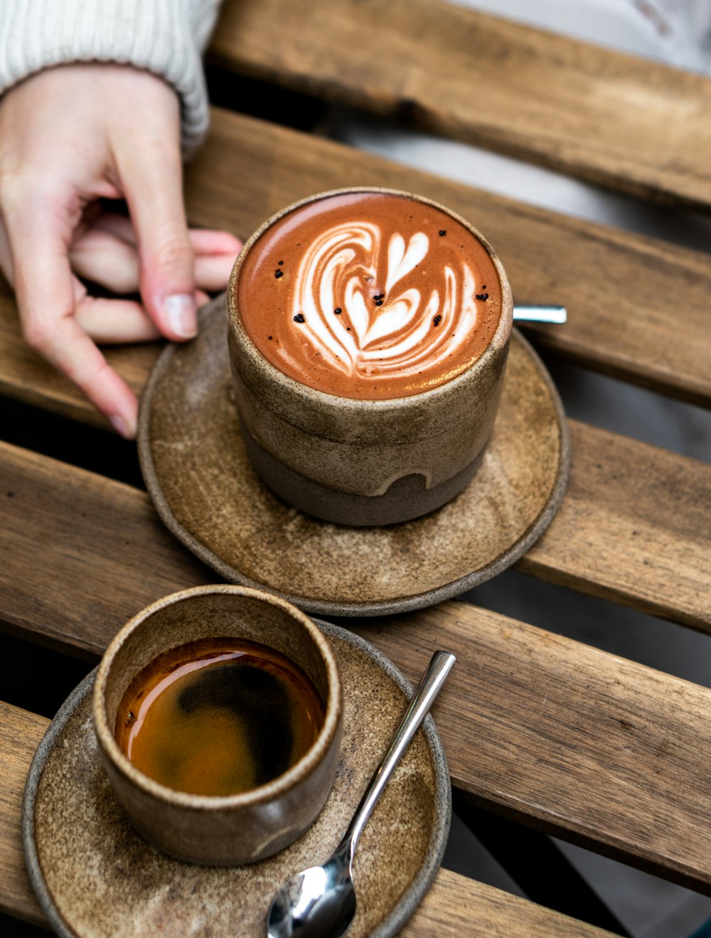 a couple of cups of coffee sitting on top of a wooden table