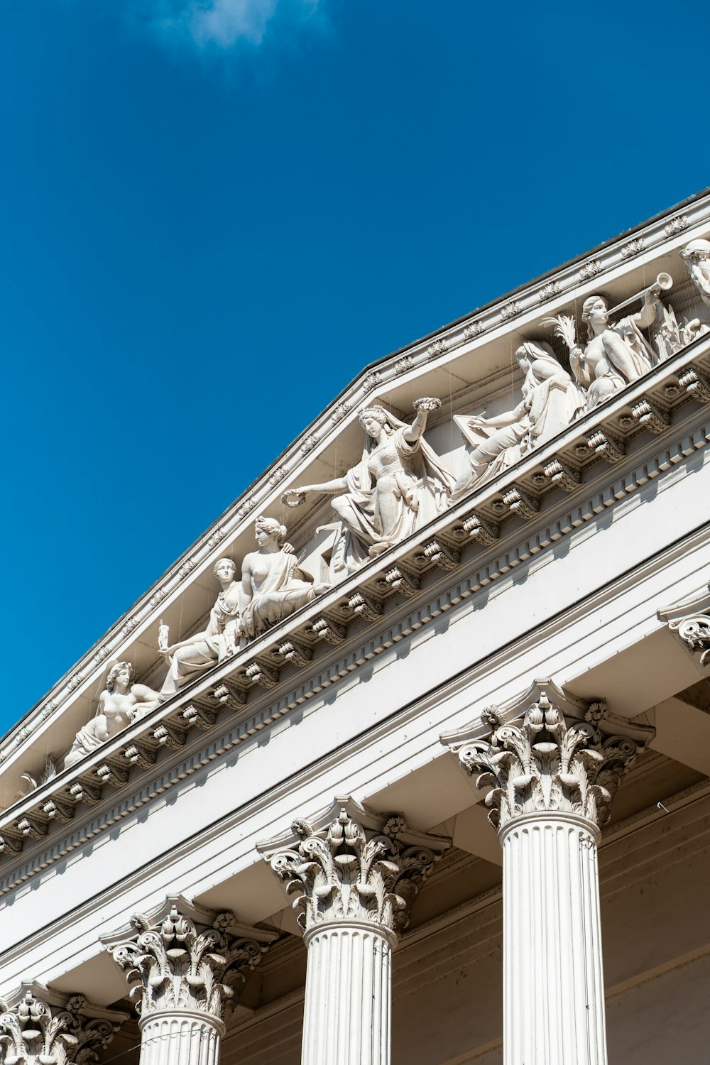 a white building with columns and statues on it