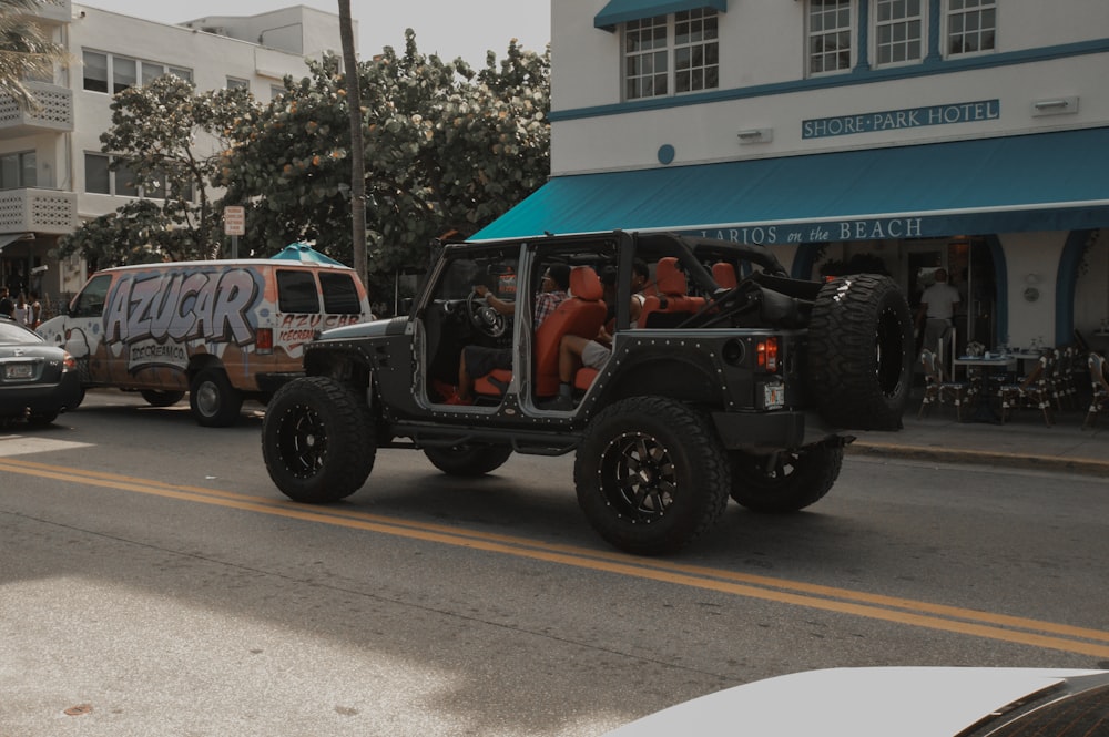 a jeep driving down a street next to a building