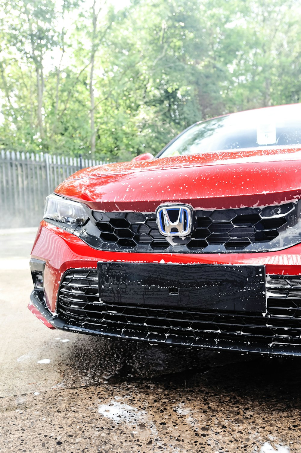 a red car is parked in the rain