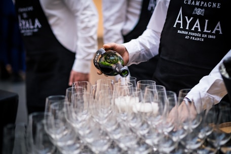 A professional waiter serving drinks at an elegant home party.