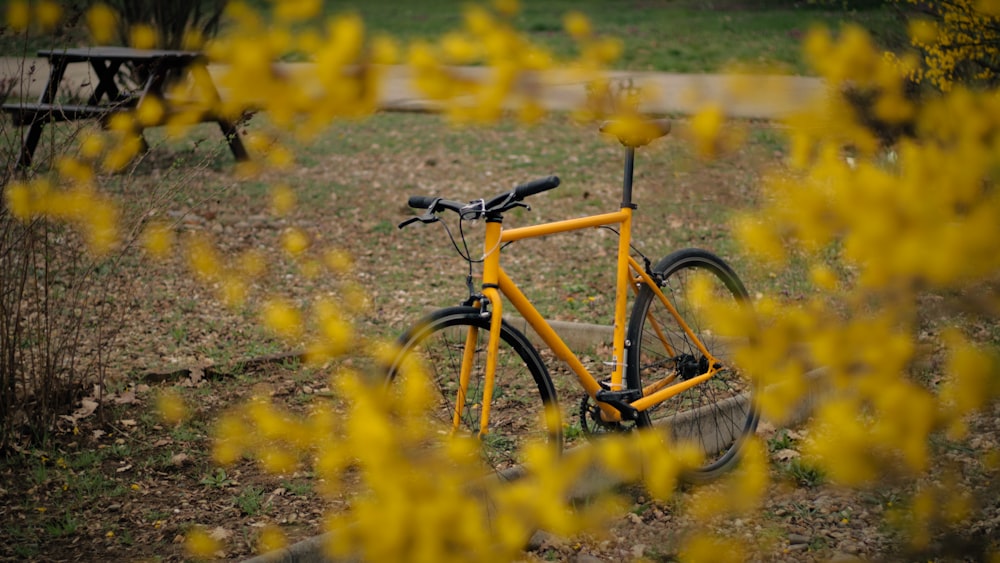 a yellow bicycle is parked in a field