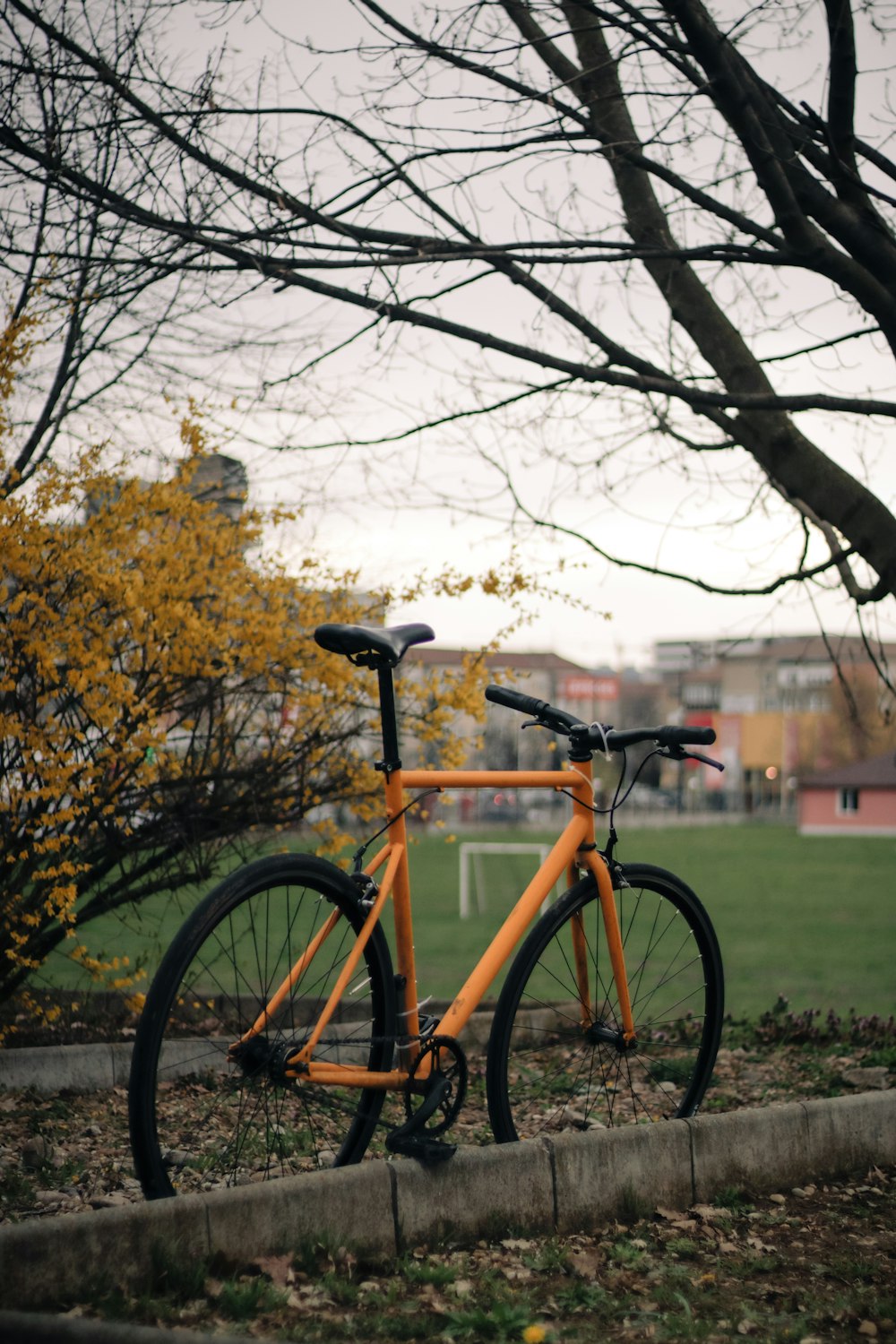 an orange bicycle parked on the side of a road