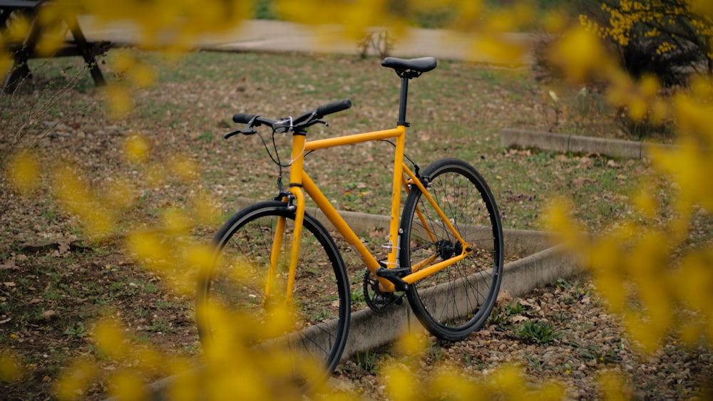 a yellow bicycle is parked in the grass