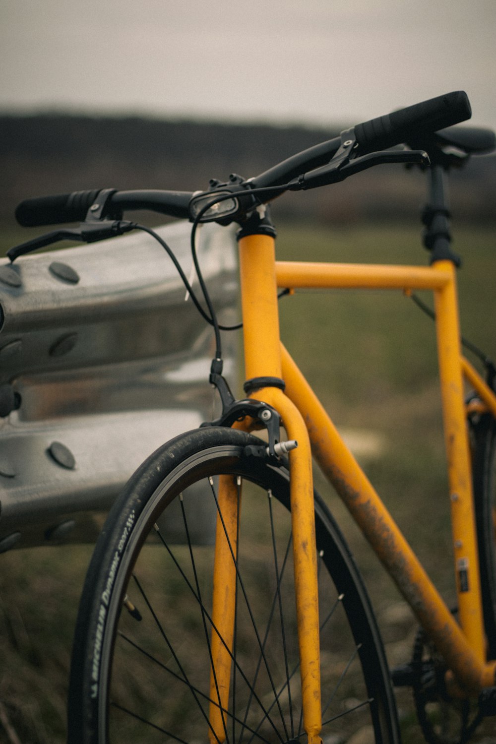 a yellow bicycle parked next to a metal bench