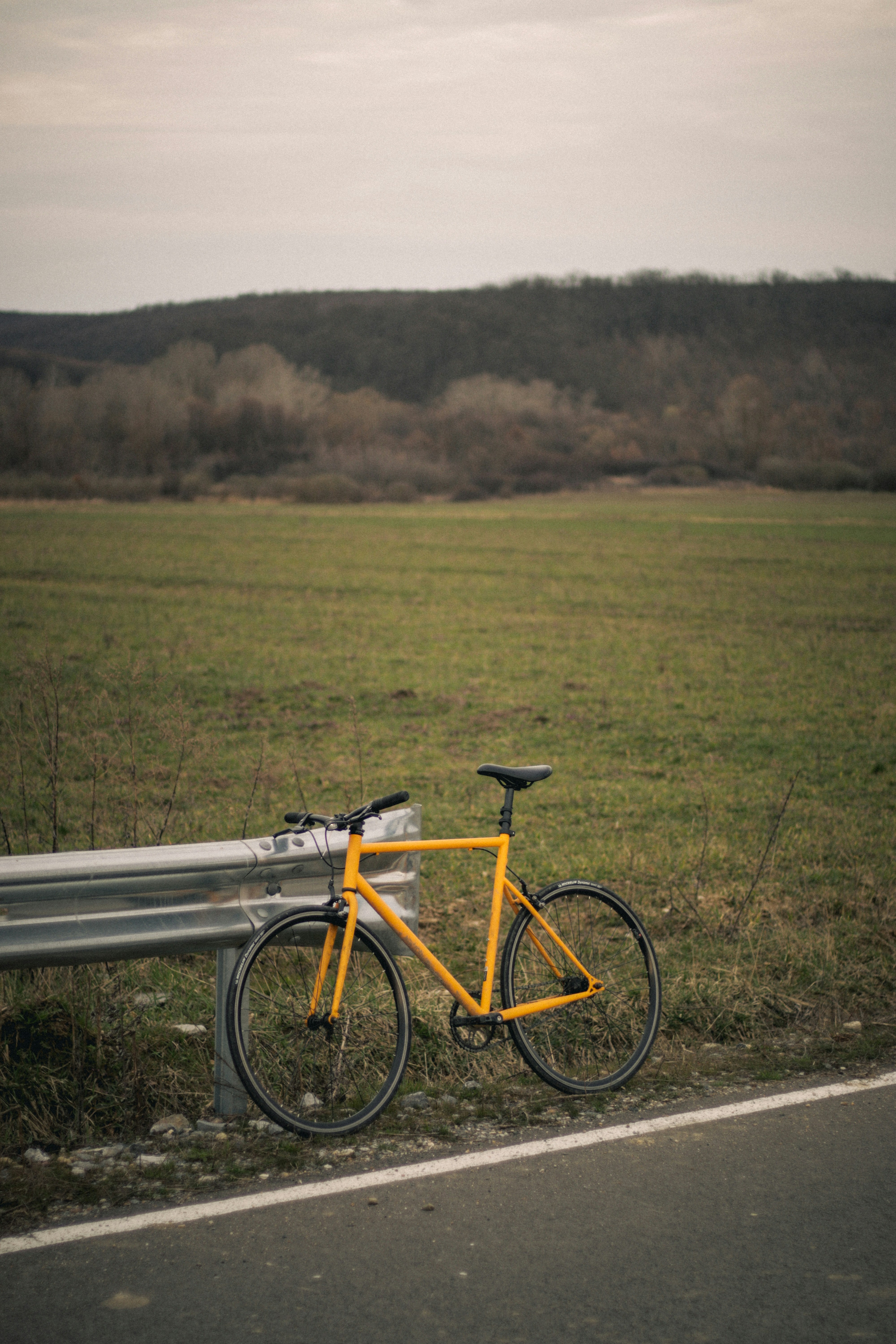a bike leaning against a bench on the side of the road