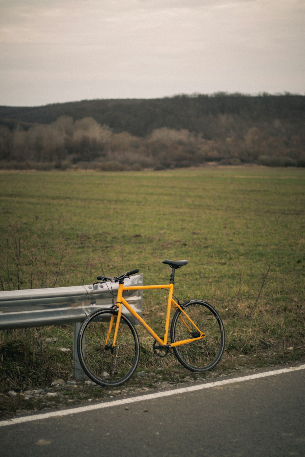a bike leaning against a bench on the side of the road