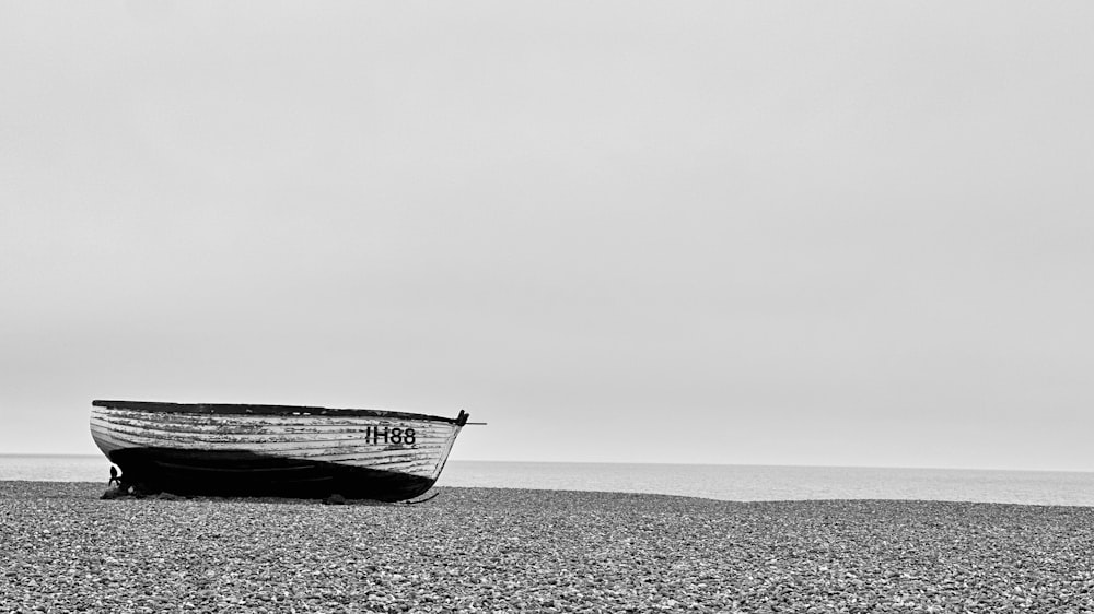 a boat sitting on top of a beach next to the ocean