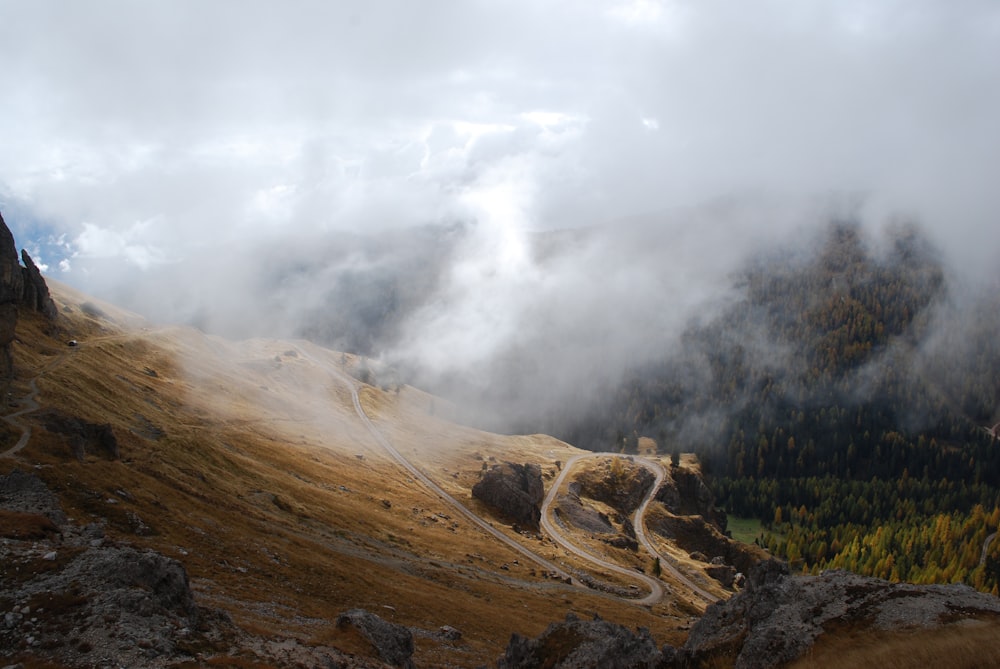 a scenic view of a mountain with a winding road in the foreground