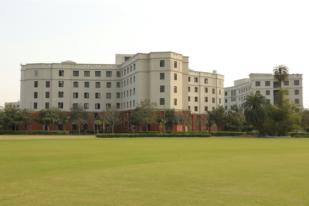a large white building sitting on top of a lush green field
