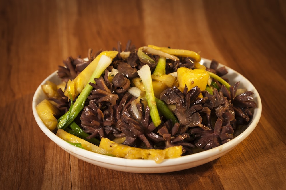 a white bowl filled with lots of food on top of a wooden table