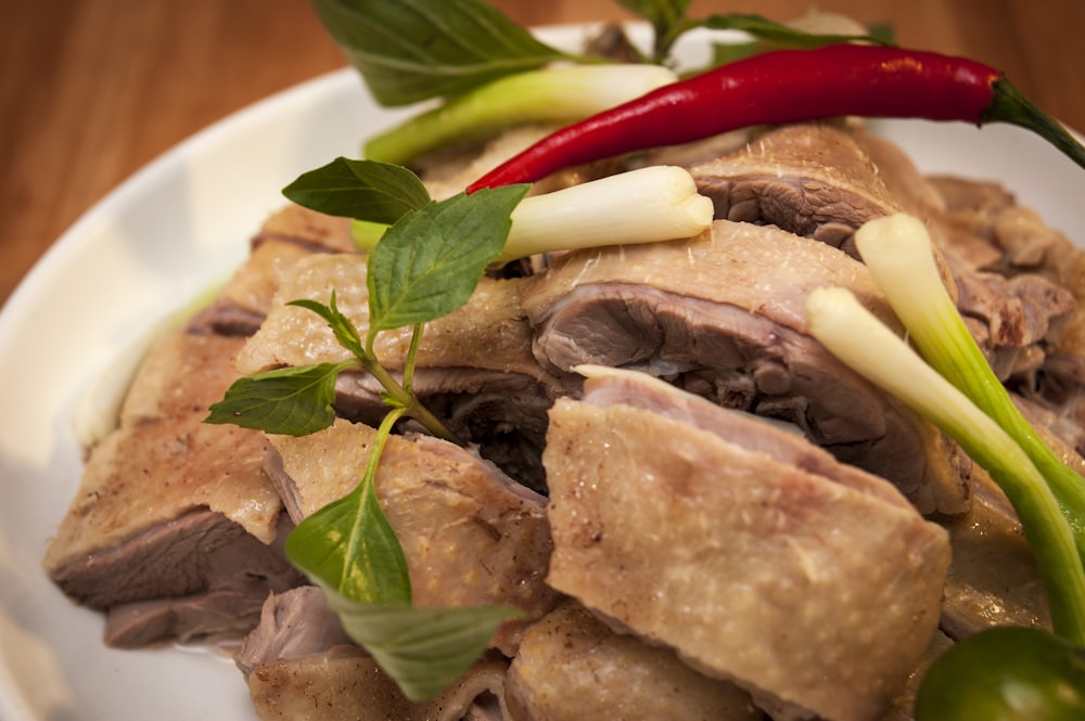 a white plate topped with meat and vegetables