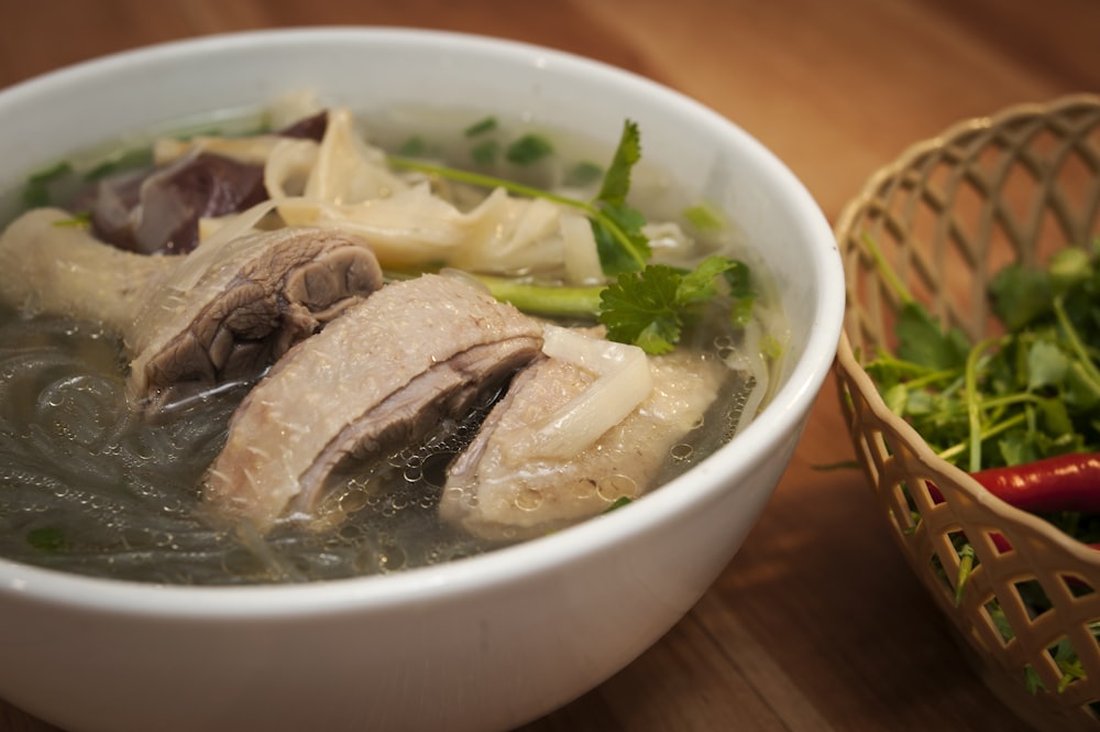 a bowl of soup with meat and vegetables in it