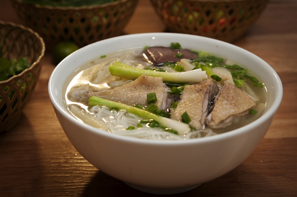 a white bowl filled with soup and vegetables