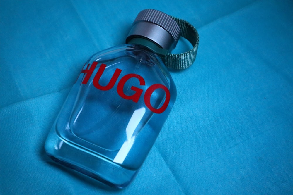 um close up de um frasco de perfume em uma superfície azul