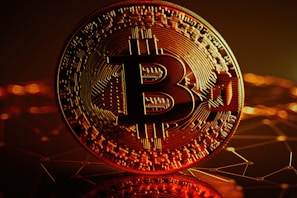 A close-up of a Bitcoin coin on a digital background.