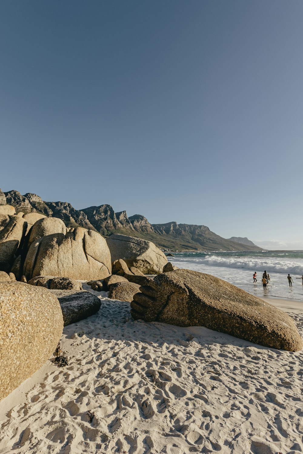 a group of people standing on top of a sandy beach