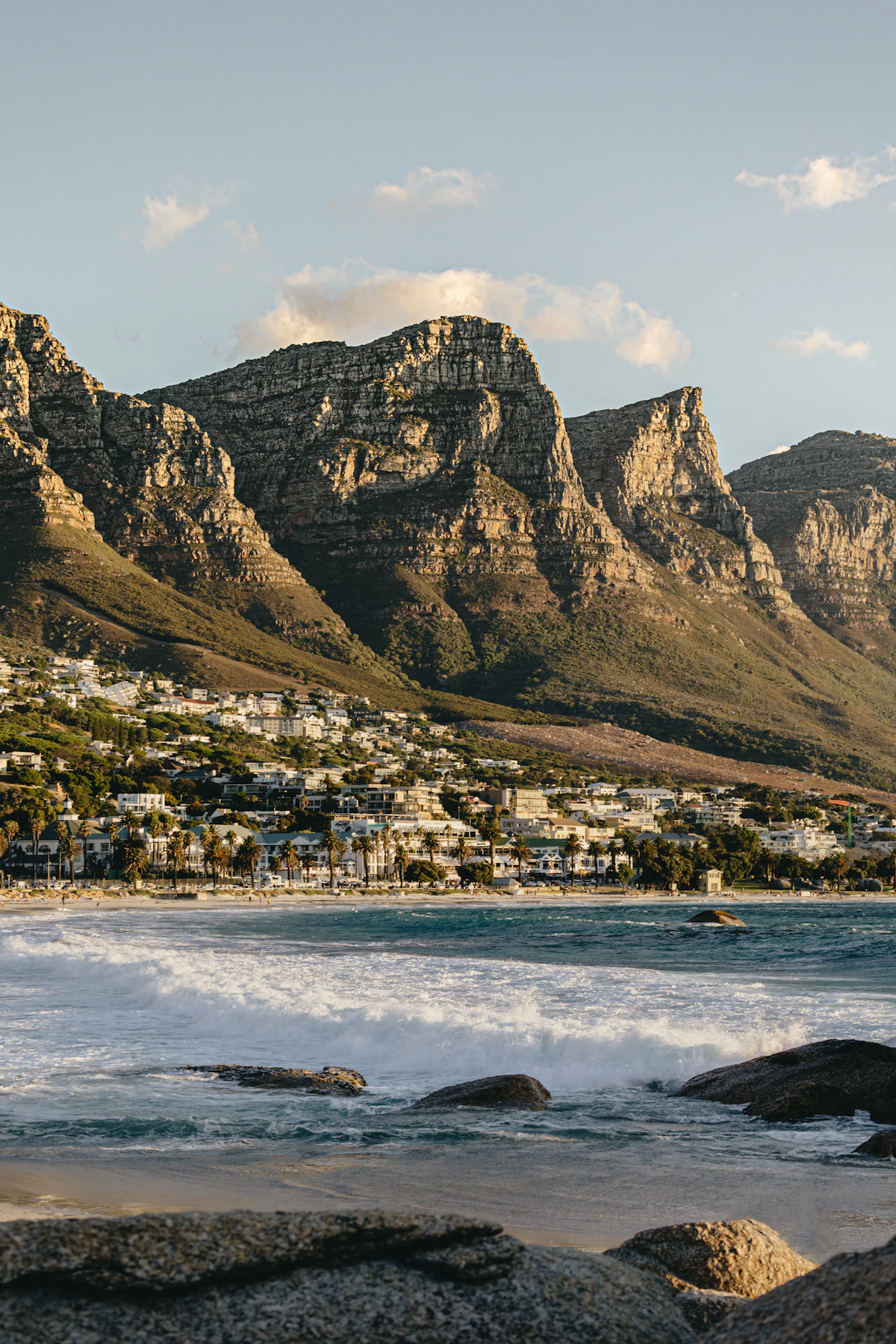 Camps Bay beach and the palm-lined promenade beneath the Twelve Apostles mountains