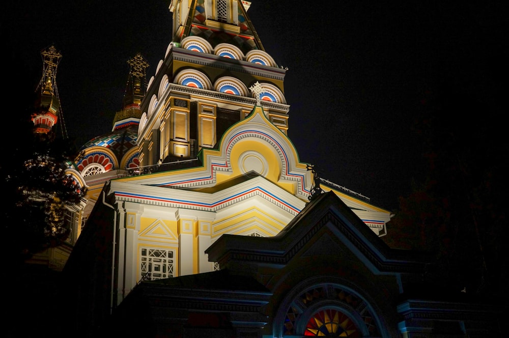 a church tower lit up at night with a clock