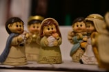 a group of little figurines of people holding a baby